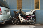 Sleeping on his Honda Dream motorbike in Hanoi