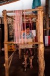 Lao woman weaving on traditional wooden loom