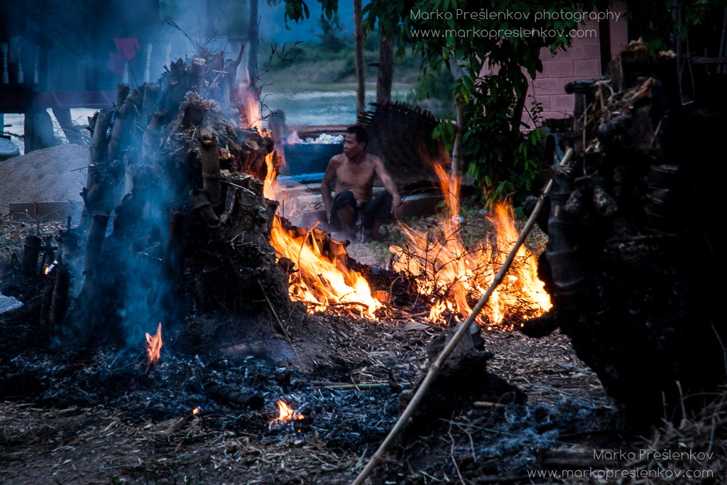 Lao man watching over fire