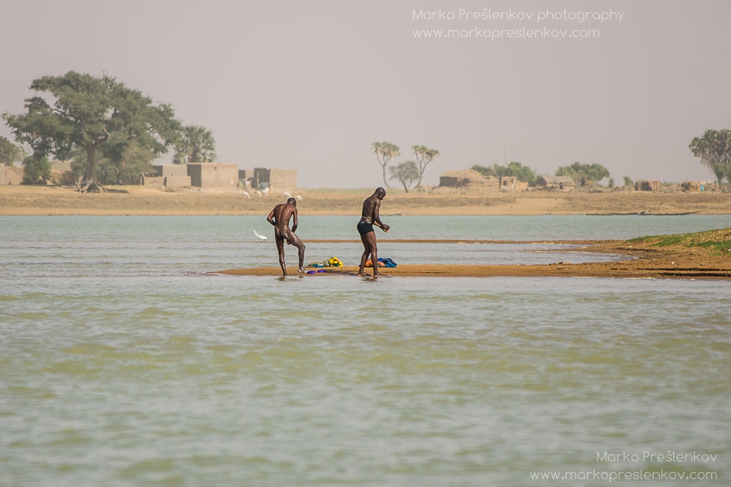 Two men washing on the banks of Niger river
