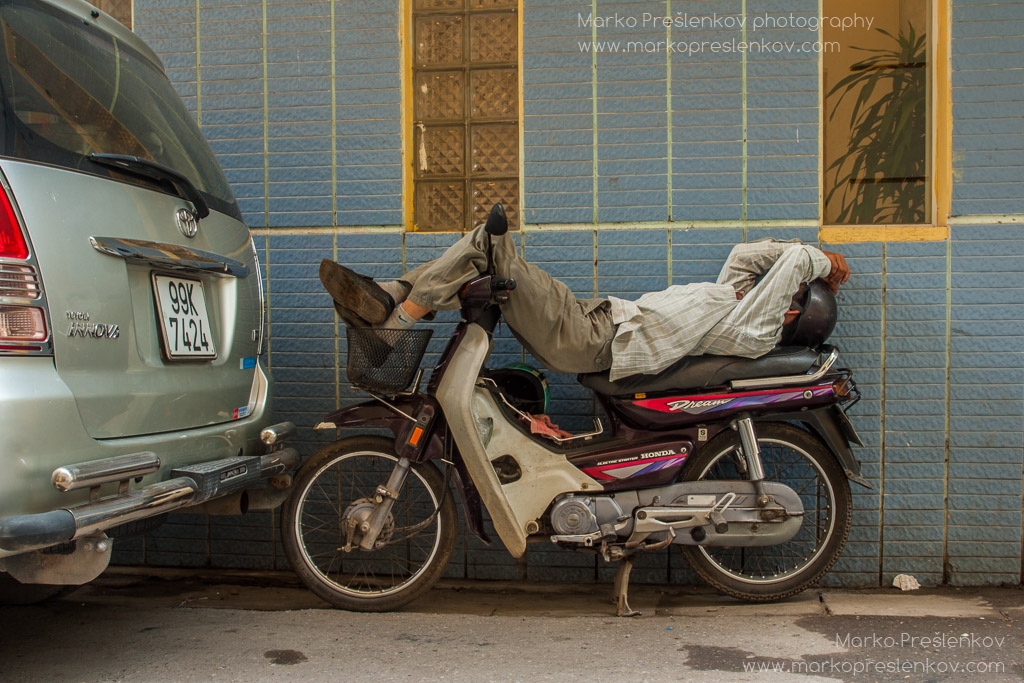 Sleeping on his Honda Dream motorbike in Hanoi