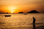 Sunset behind a swimmer on Bounty Beach