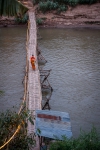 Buddhist monks strolling over bamboo bridge