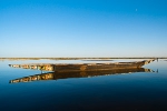 Lone pirogue sitting on a Niger river near ferry crossing for Timbuktu at Tombouctou fleuve, Mali. Photo by Marko Preslenkov.