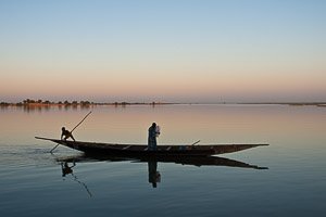 A Tuareg man returning home as a passanger in pirogue on Niger river at Tombouctou fleuve near Timbuktu, Mali. Photo by Marko Preslenkov.